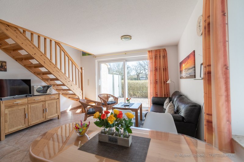 Wohnzimmer mit Holztreppe und Terrassenzugang – Ferienwohnung 4 Personen